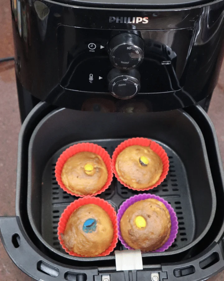 Air fryer banana muffins baked in colorful silicone cups inside the air fryer basket
