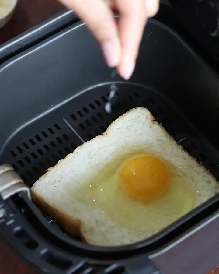 Egg toast in the air fryer basket cooking until golden