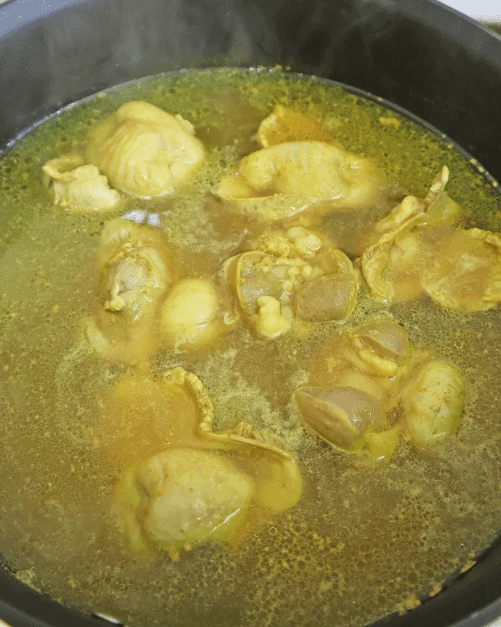 Seasoned chicken gizzards arranged in a single layer inside an air fryer basket