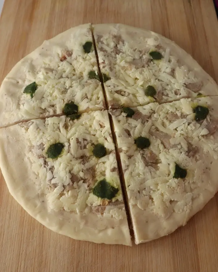 Frozen pizza cooking in the air fryer basket with cheese melting and the crust browning