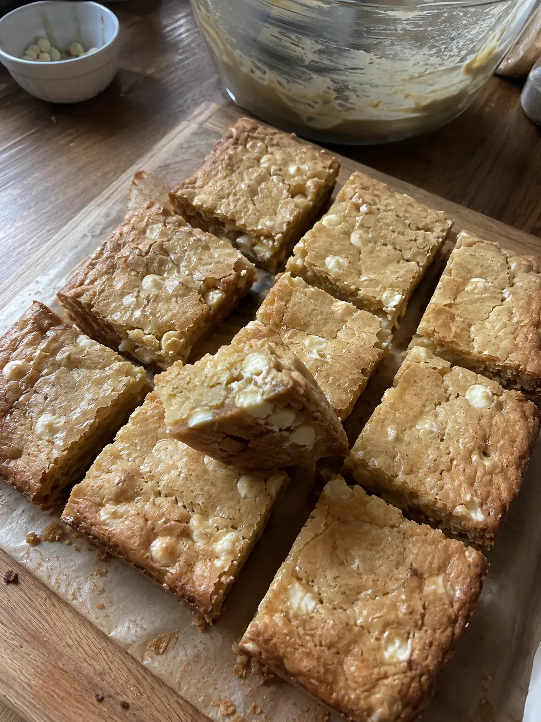 Air fryer blondies cut into squares on a wooden board, one turned on its side to show the dense interior
