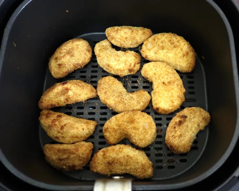 Golden breaded apple fries cooked in a single layer in an air fryer basket