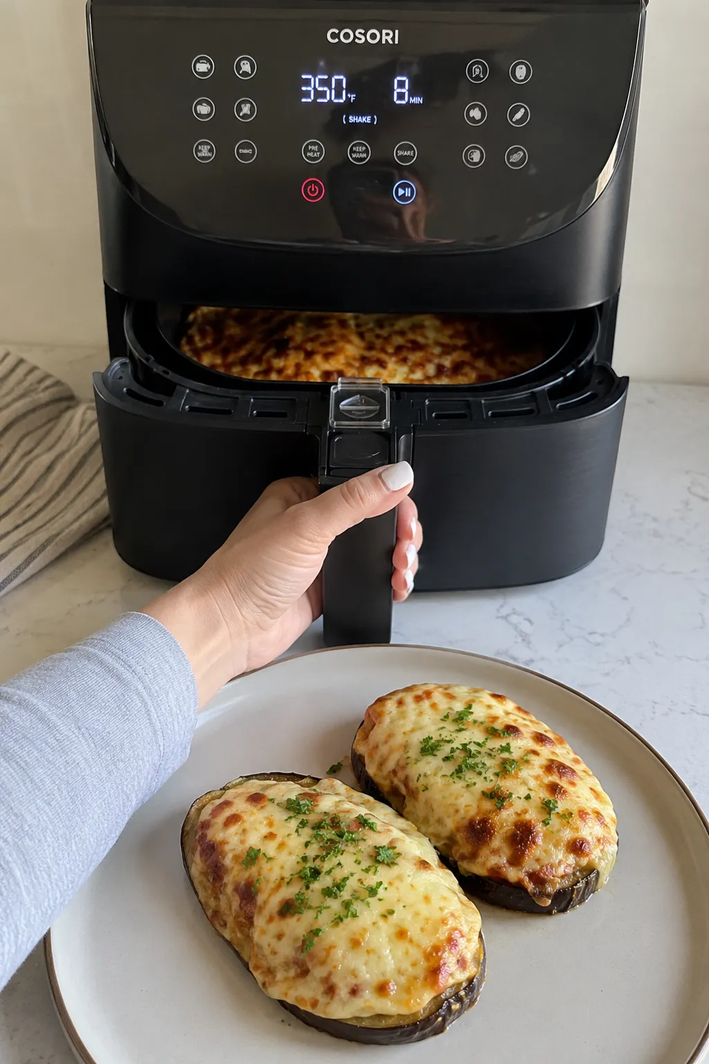 Cheesy stuffed eggplant with browned melted cheese cooked in a basket air fryer