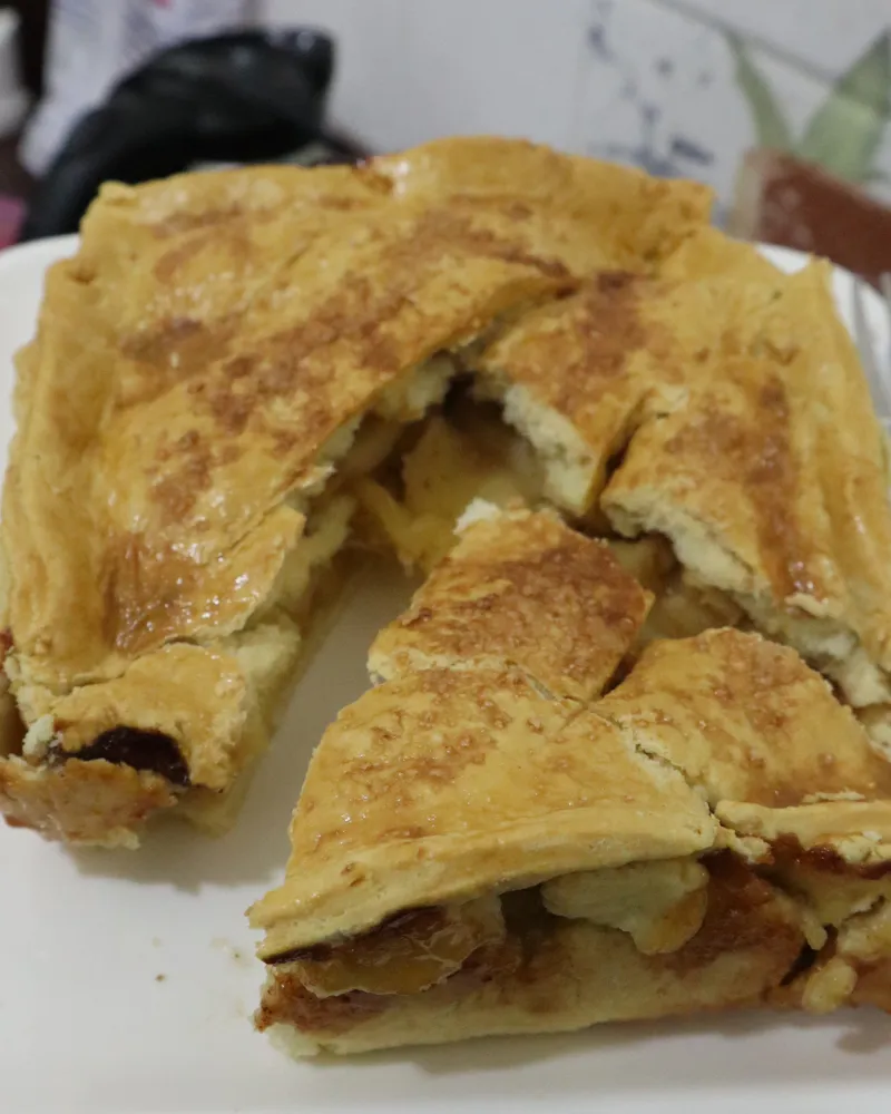 A cut air fryer apple pie on a plate with the filling packed up against the top crust