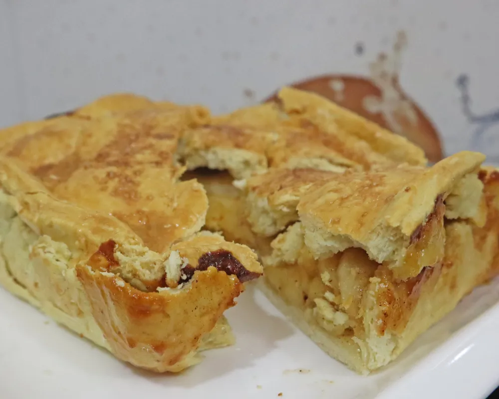 Air fryer apple pie cut into pieces on a white plate showing the apple filling
