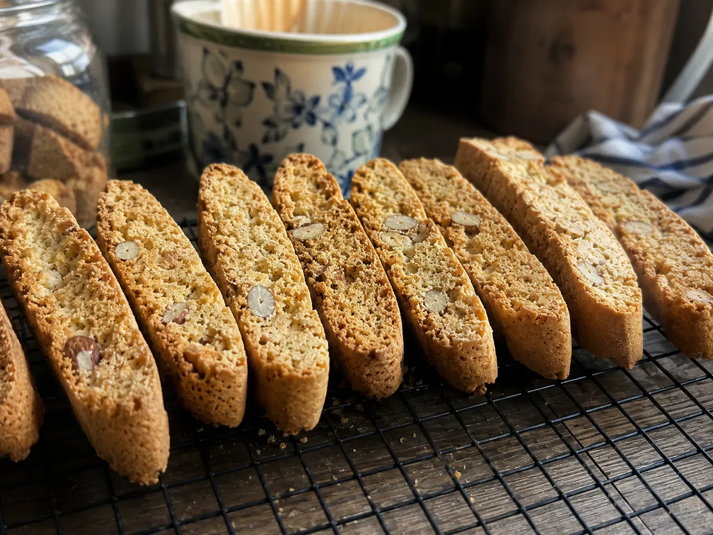 Finished almond biscotti standing in a row on a cooling rack