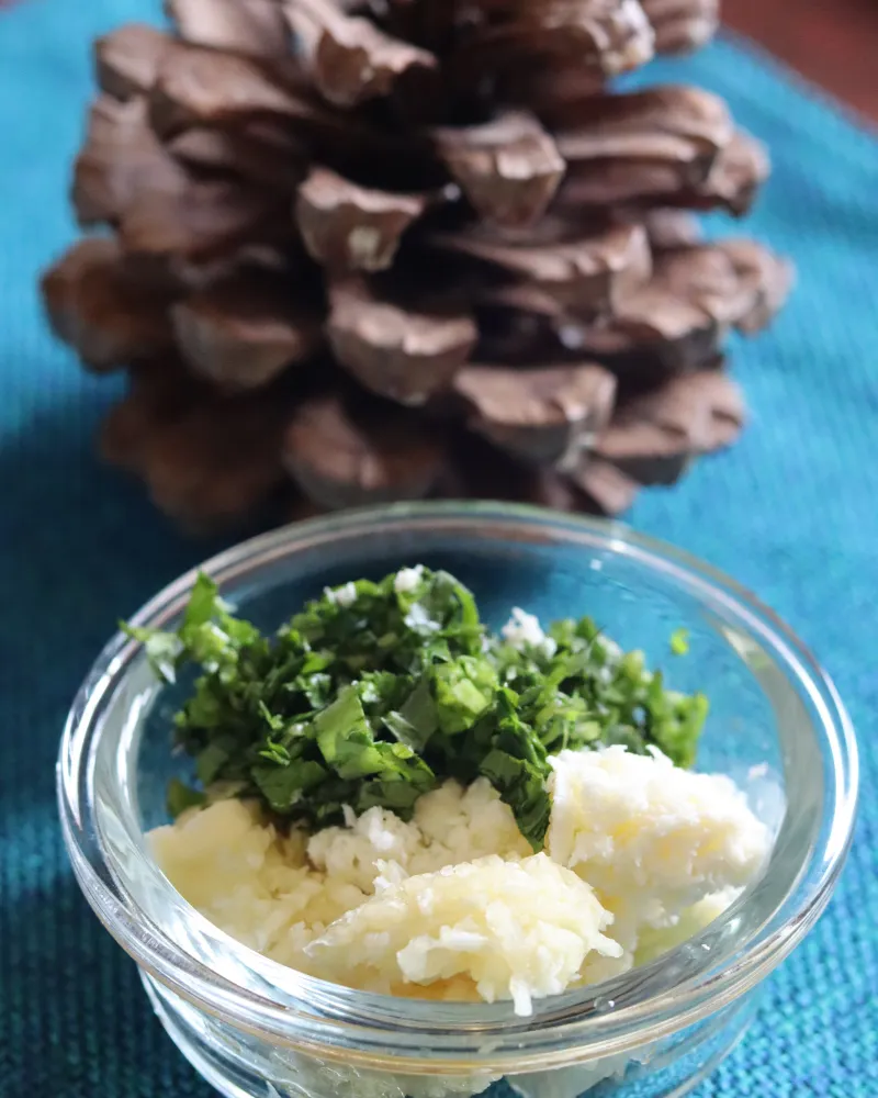 Softened butter, grated garlic paste and chopped fresh parsley together in a small glass bowl