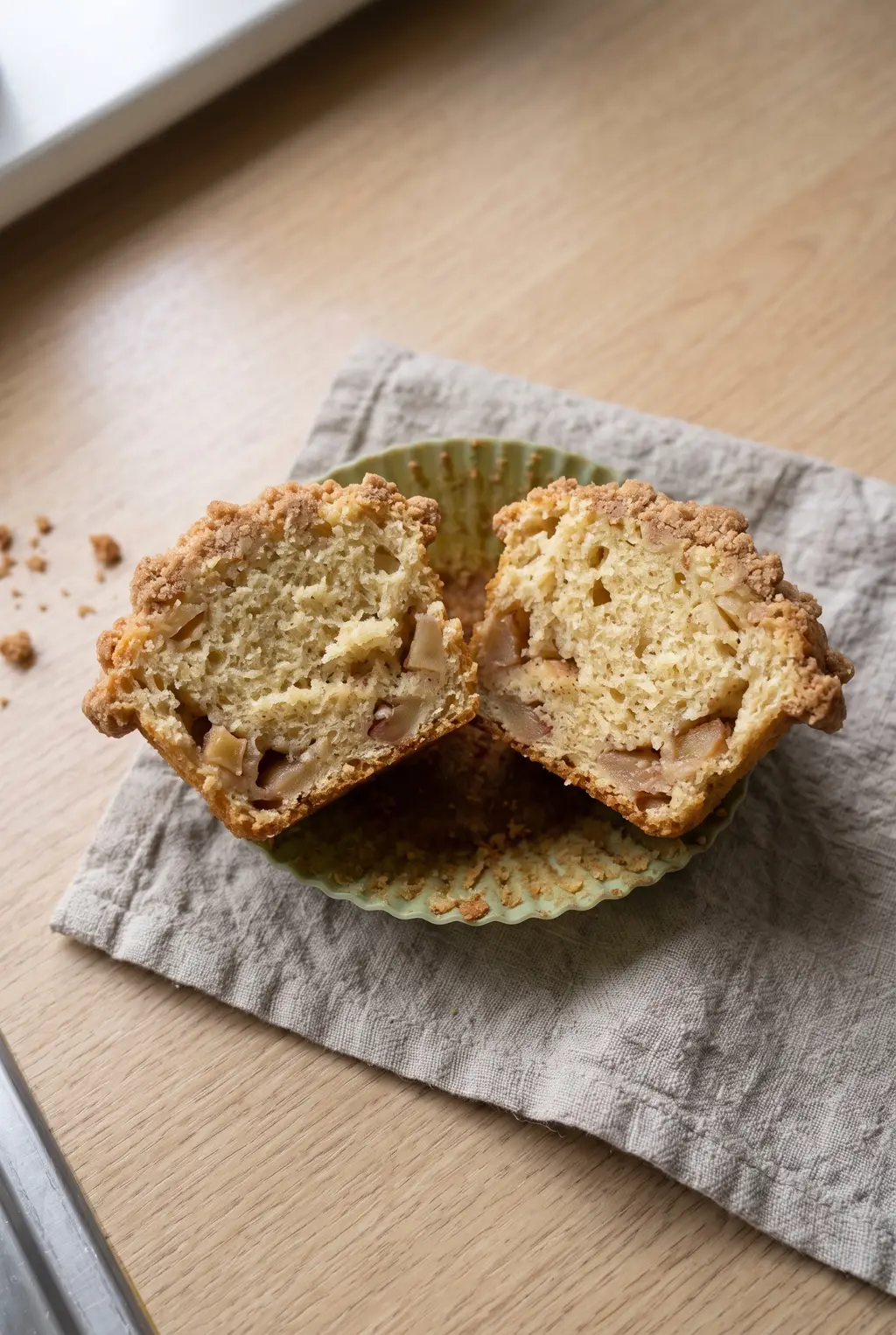 Close-up of a split air fryer apple muffin showing a moist crumb with apple pockets throughout