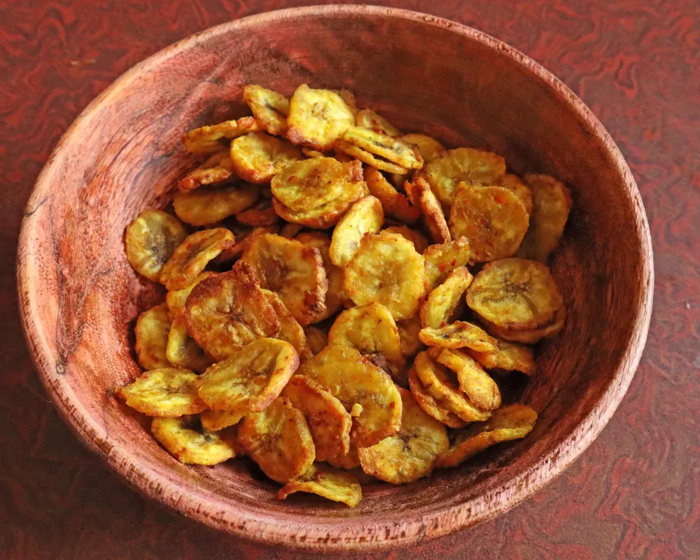 A wooden bowl of finished golden banana chips