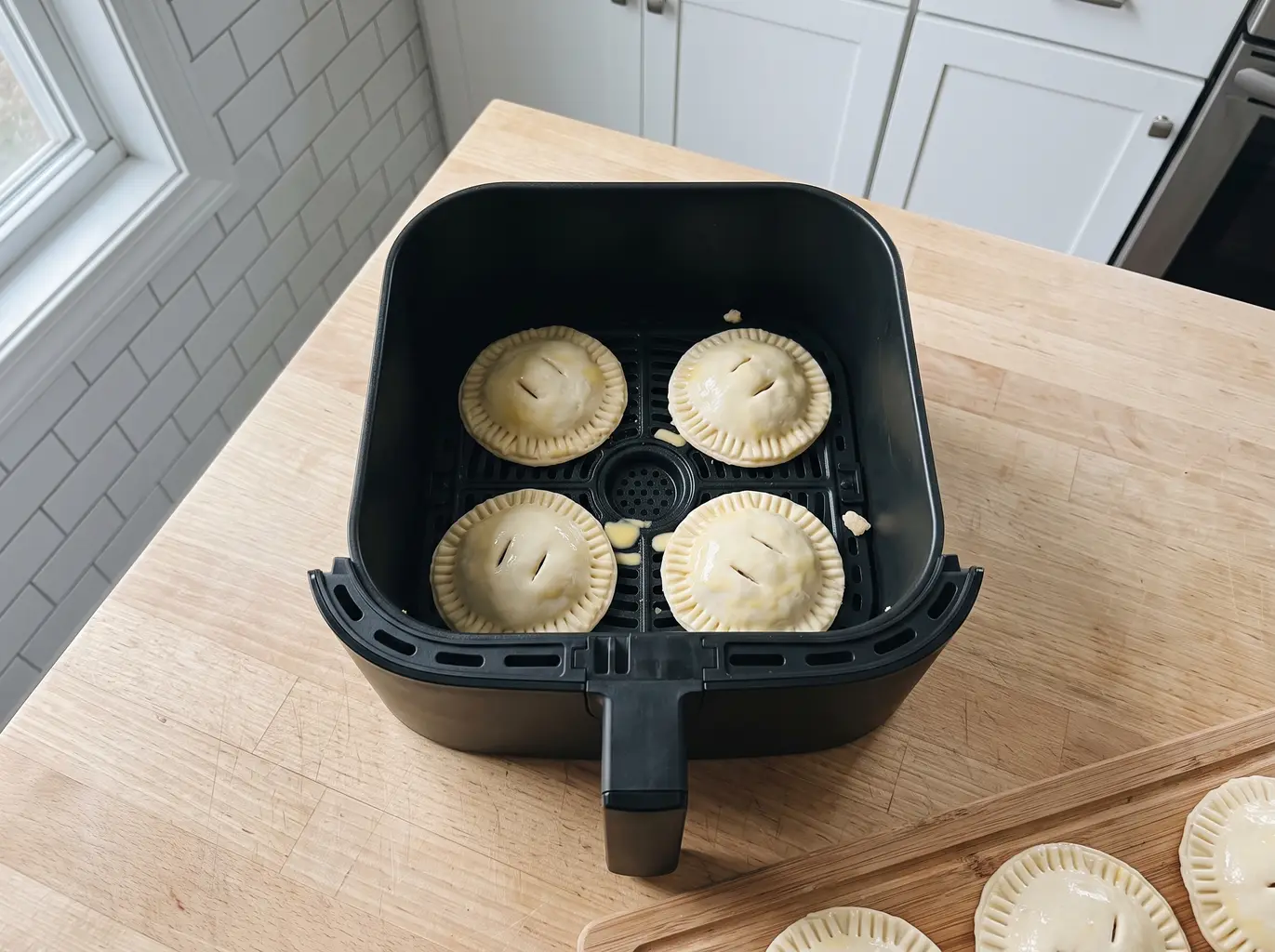 Pumpkin hand pies arranged in the air fryer basket