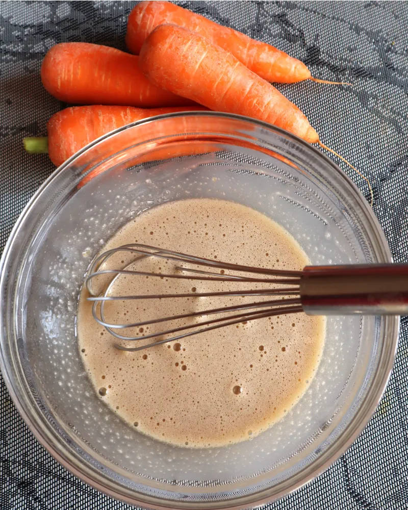 Eggs, sugar and oil whisked to a pale frothy batter in a glass bowl