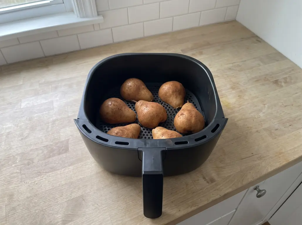 Pear halves set cut side down in an air fryer basket