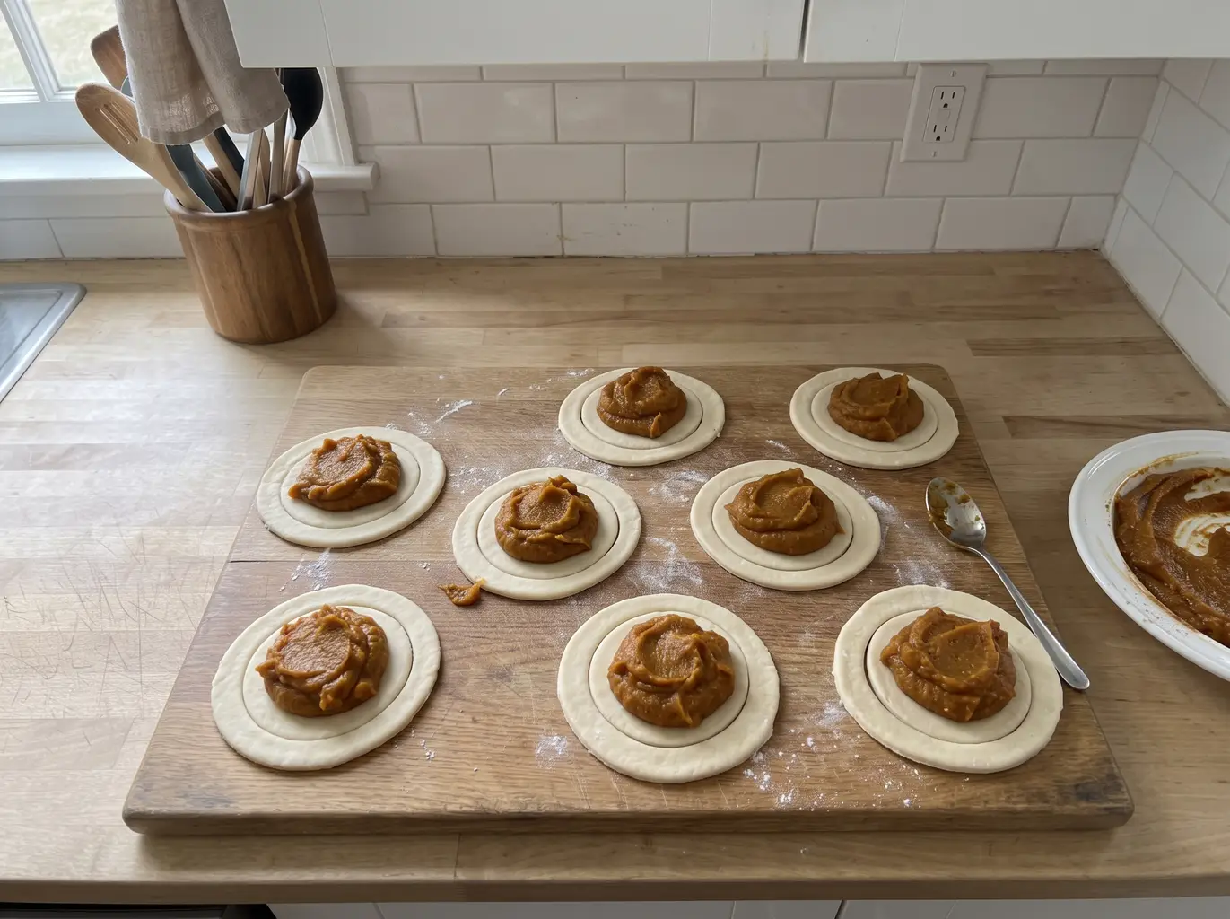 Spooning cooked pumpkin filling onto crust rounds