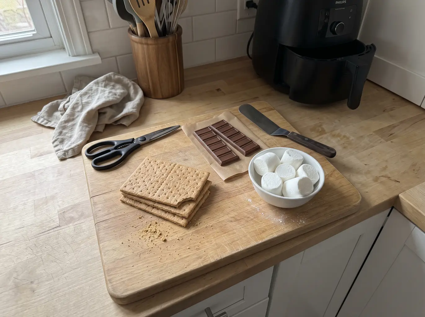 Graham crackers, chocolate bars and a bag of marshmallows laid out on a counter
