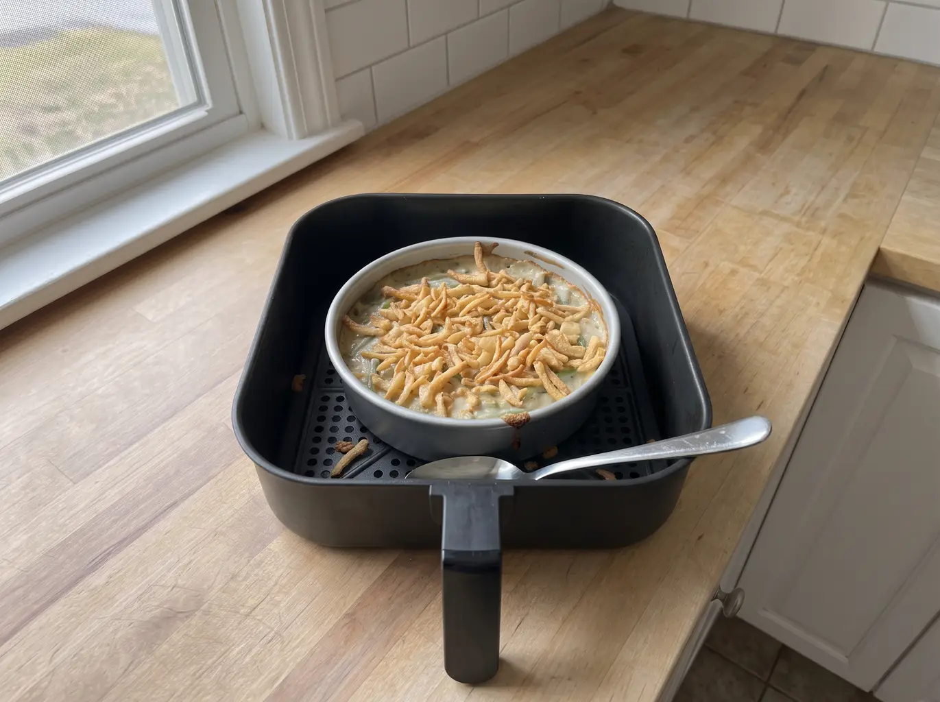 Bubbling green bean casserole in the air fryer basket