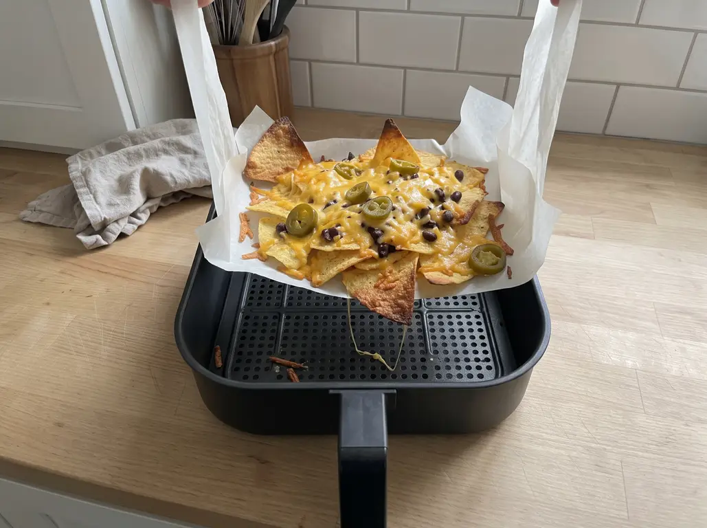 Lifting the nachos out by the parchment flaps